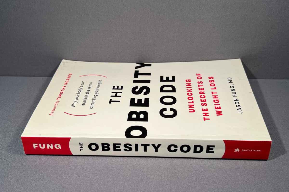 A paperback copy of The Obesity Code by Dr Jason Fung lying on a grey surface.