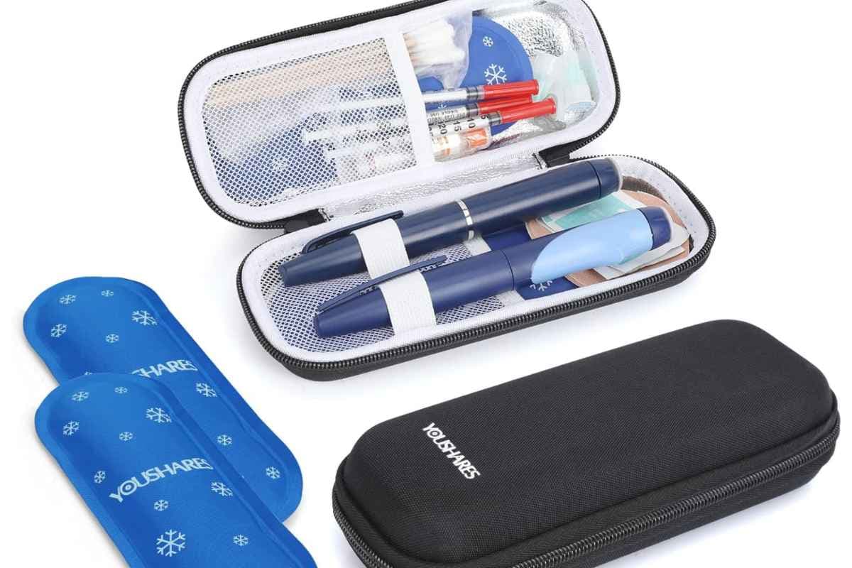 An open insulated medication case holding two injection pens, with blue gel cool packs and a closed carry case beside it.